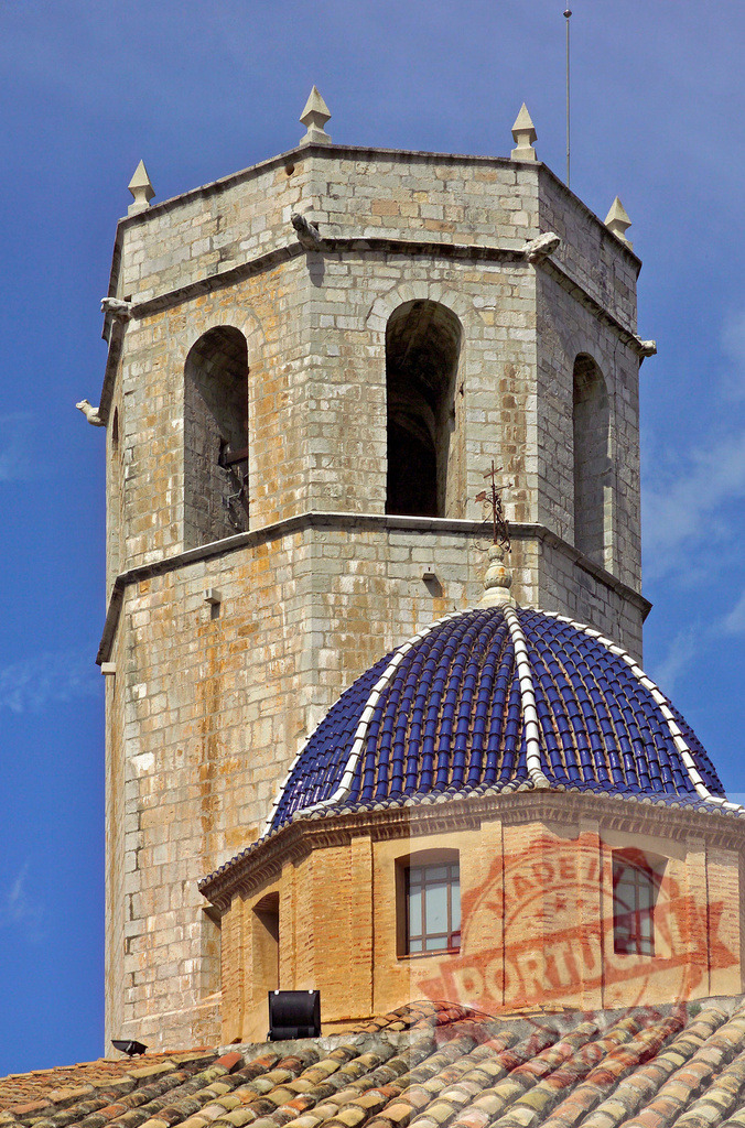 Church bell tower with blue tiled dome against sky | Historic religious architecture with stone bell tower and vivid blue tiled dome under clear sky - Realized with Pictrs.com