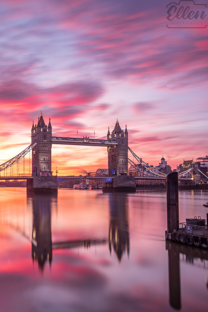 Morning Glow | Soft hues of pink and gold rise over Tower Bridge as London awakens. The still water mirrors the sky, capturing a moment of quiet beauty before the city begins to move. - Realisiert mit Pictrs.com