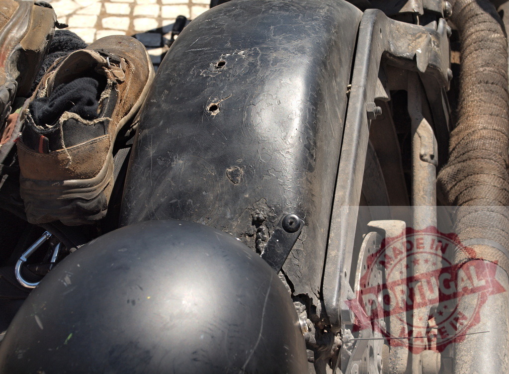 Worn shoes, helmet, custom motorcycle parts displaying rugged journey | Detail of worn shoes, black helmet, and weathered custom motorcycle parts showing a hard journey - Realisiert mit Pictrs.com