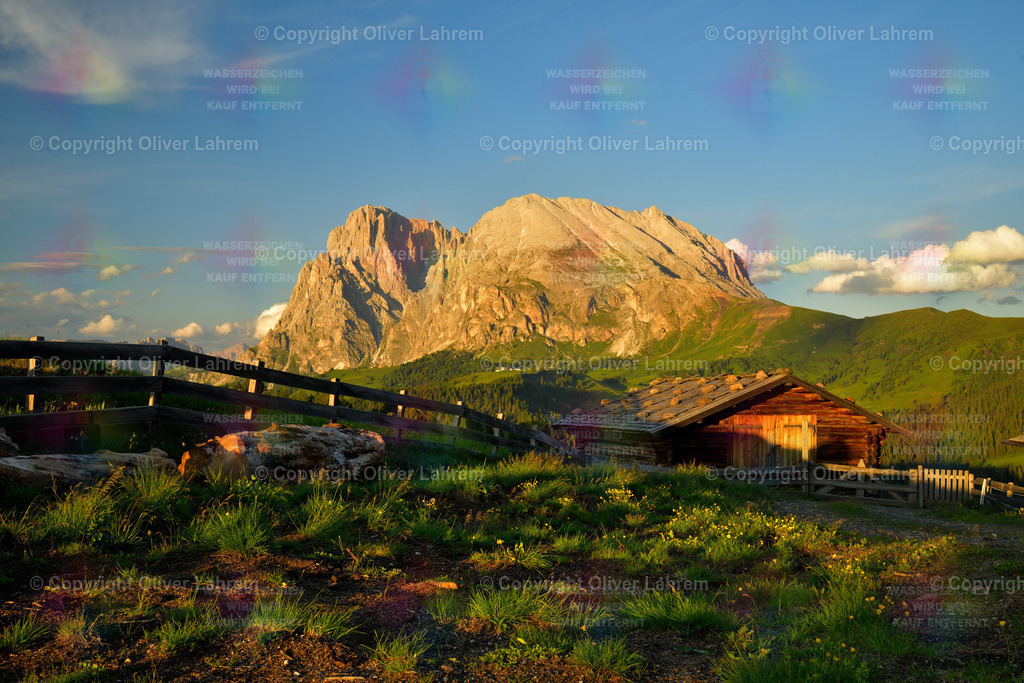 Dolomitenglück | Idyllisch steht eine kleine Almhütte in der Abendsonne, und im Hintergrund leuchten Lang- und Plattkofel im Licht. Einfach eine wunderschöne Szenerie wie man sich die Südtiroler Dolomiten vorstellt.
