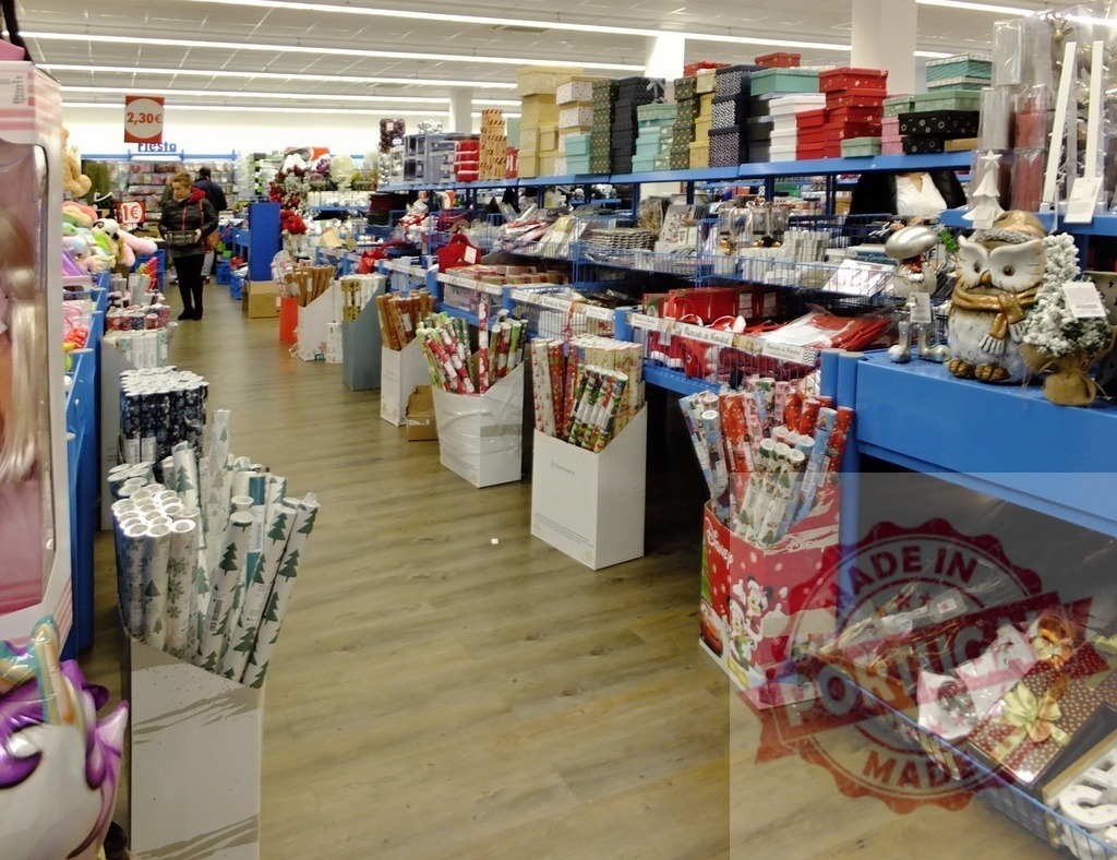 Store aisle displaying Christmas gift wrap, boxes, and festive decorations | Interior view of a retail store aisle filled with holiday gift wrap, boxes, and seasonal decorations - Realized with Pictrs.com