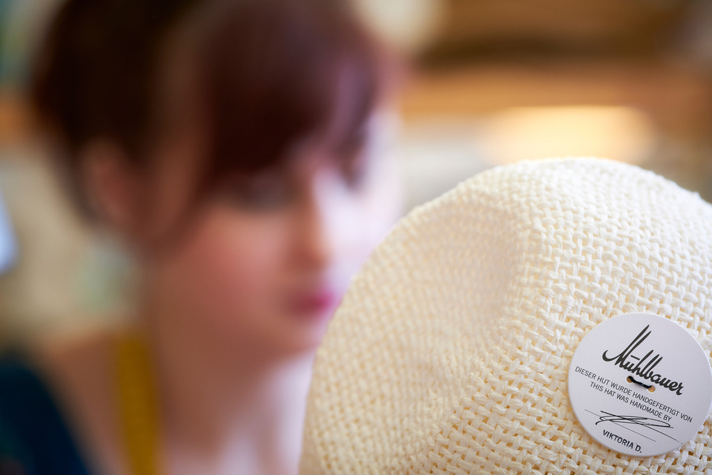 Mühlbauer Hutmanufaktur | WIen, Austria - March 04, 2020; Mühlbauer Hutmanufaktur; eine Modistin bearbeiten den Hut mit sichtbarem Logo. - Realisiert mit Pictrs.com