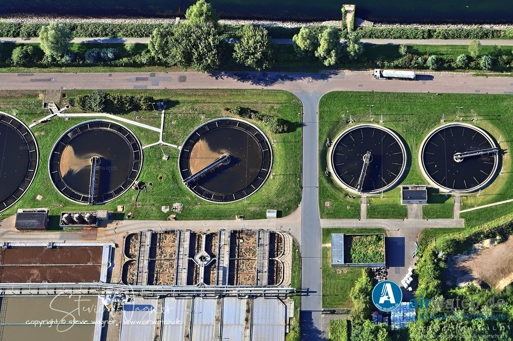 Luftbild Klärwerk in Flensburg - Es versorgt neben Flensburg und Glücksburg auch die Gemeinden Harrislee, Jarplund-Weding, Wees, Tastrup, Handewitt | Das Klärwerk in Flensburg, Teil des Technischen Betriebszentrums (TBZ) seit 2008, reinigt jährlich rund 11 Millionen Kubikmeter Abwasser und verfügt über eine Kapazität für 224.000 Einwohnergleichwerte. Es versorgt neben Flensburg und Glücksburg auch die Gemeinden Harrislee, Jarplund-Weding, Wees, Tastrup sowie das Gewerbegebiet Handewitt. Auf einem 7,5 Hektar großen Gelände wird das Abwasser über ein rund 300 Kilometer langes Kanalnetz aufgenommen, wobei an trockenen Tagen etwa 28.000 m³ und an starken Regentagen bis zu 60.000 m³ gereinigt werden. Das gereinigte Wasser wird der Flensburger Förde zurückgeführt. Rund 80 Mitarbeiter arbeiten teilweise im 24-Stunden-Schichtbetrieb.