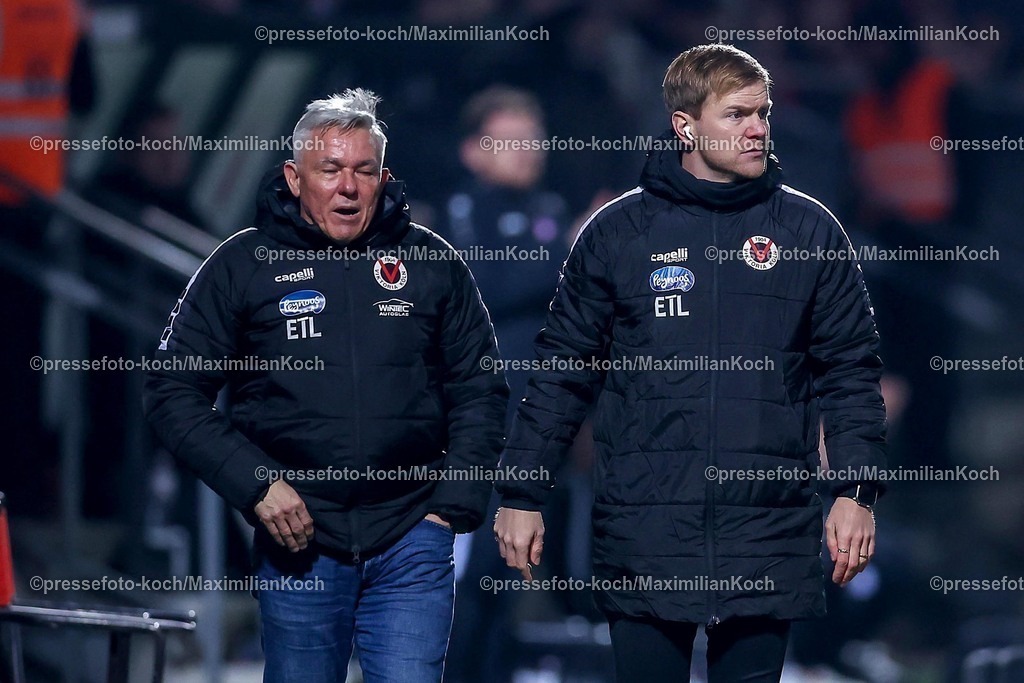 Koe12032501149 | 12.03.2025, Fußball, FC Viktoria Köln – Rot-Weiss Essen, 3.Liga, Sportpark Höhenberg, Saison 2024 2025: Co-Trainer Marian Wilhelm (Viktoria Köln) und Cheftrainer Olaf Janßen (Trainer Viktoria Köln) stehen zusammen am SpielfeldrandDFB regulations prohibit any use of photographs as image sequences and or quasi-video.