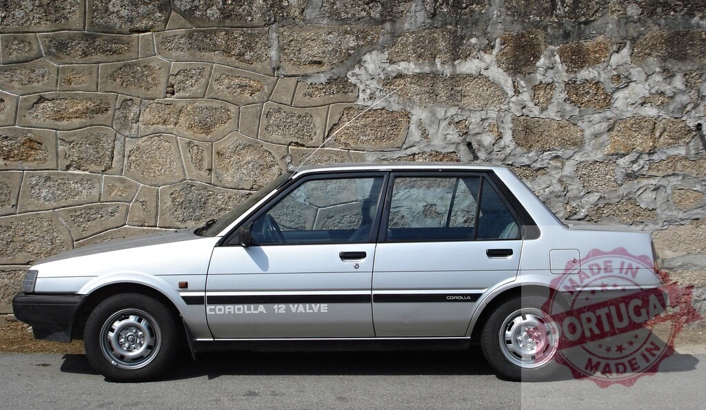 Silver Toyota Corolla 12 Valve parked near stone wall | Classic silver Toyota Corolla 12 Valve parked near a stone wall, showcasing its timeless design - Realisiert mit Pictrs.com
