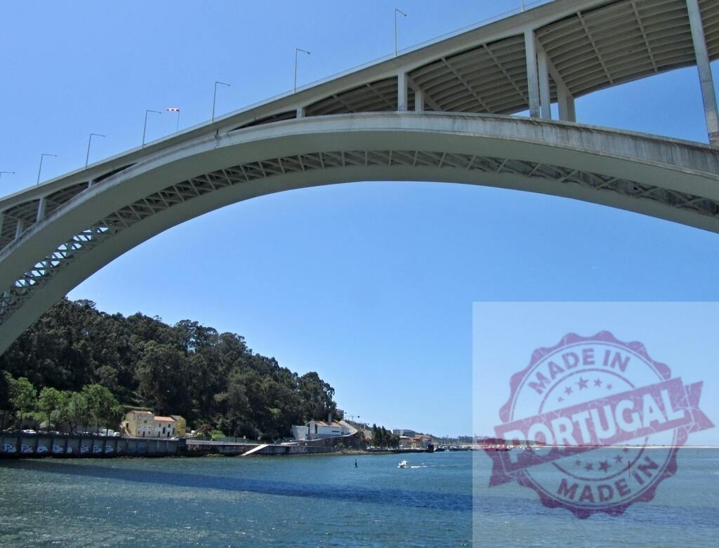 Ponte da Arrábida bridge arching over Douro river in Porto | Ponte da Arrábida bridge concrete arch spanning the Douro river under a clear blue sky - Realisiert mit Pictrs.com