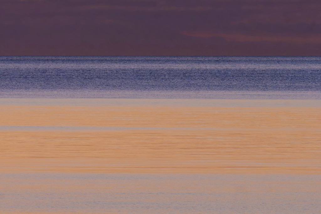 Das Orange Meer | Orangefarbene Wolken weit oberhalb des Horizonts reflektieren kurz nach Sonnenuntergang auf dem Meer - Realisiert mit Pictrs.com