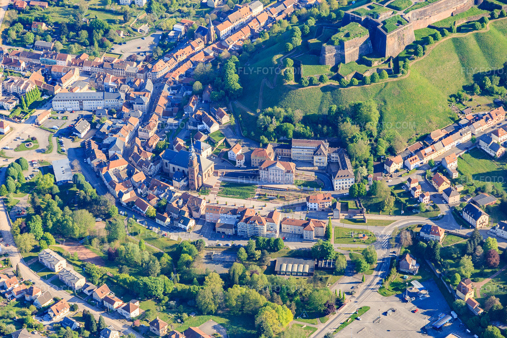 Aerial view: Town center with town hall and church in Bitche in the state Moselle, France. – Photo: IMG_146067.jpg taken on 05/01/2025 by Werner Riehm/FLY-FOTO.com – Resolution of the original: 5472 x 3648 px – Ville de Bitche