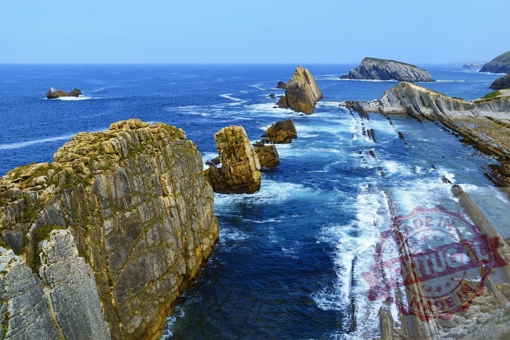Arnia beach geological rock formations and blue Cantabrian sea. Spain - Cantabria | Flysch rock formations and stacks in the blue ocean with waves crashing on the coast - Realized with Pictrs.com