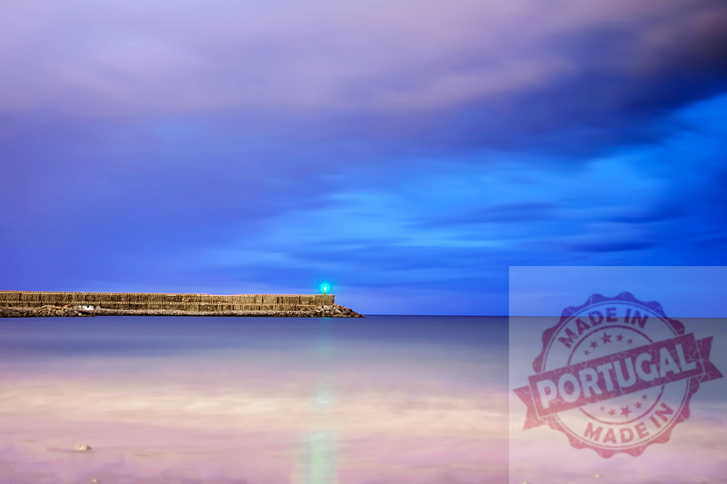 Breakwater and green light illuminating blue night seascape | Long exposure of a seascape with breakwater and green light at dusk - Realisiert mit Pictrs.com