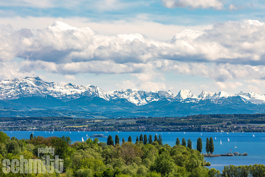 Blick auf den Bodensee mit den Alpen im Hintergrund | Ein weiter Blick über den Bodensee bei Unterhuldingen-Mühlhofen lässt den See und die majestätische Alpenkulisse am Horizont miteinander verschmelzen. Die klare Weite der Landschaft und das ruhige Wasser schaffen ein zeitloses Panorama voller Ruhe und beeindruckender Natur. - Realisiert mit Pictrs.com