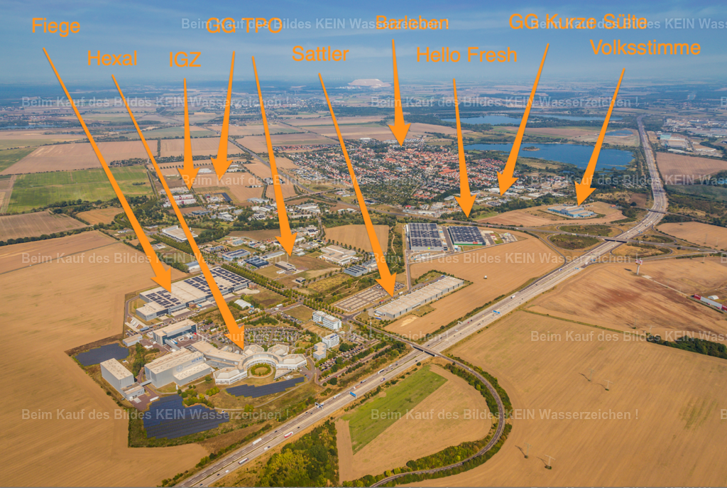 Barleben mit Verortung | Blick aus dem Tragschrauber auf die Gewerbe- und Unternehmensstandorte entlang der Otto-von-Guericke-Allee in Barleben. Links und rechts der Verkehrsachse liegen unter anderem Standorte von Salutas, Fiege, HelloFresh und der Volksstimme.Die Aufnahme reicht weit über die einzelnen Unternehmensgebäude hinaus. Im Vordergrund ist die Autobahn A2 zu erkennen, während der Blick bis nach Barleben und in die weitere Umgebung reicht. Durch Pfeile und Beschriftungen werden die einzelnen Standorte direkt im Luftbild verortet.Solche Aufnahmen sind mehr als reine Unternehmensfotografie: Sie zeigen einen Standort im räumlichen Zusammenhang mit seinen Nachbarn, Verkehrswegen und der umgebenden Infrastruktur.Die Kombination aus Luftbild, klarer Verortung und Beschriftung gehört zu meinem Service für Standortmarketing. Gerade für Wirtschaftsförderungen, Kommunen, Gewerbegebiete und Unternehmen lässt sich damit anschaulich zeigen, wo ein Standort liegt und welche Infrastruktur ihn umgibt. - Realisiert mit Pictrs.com