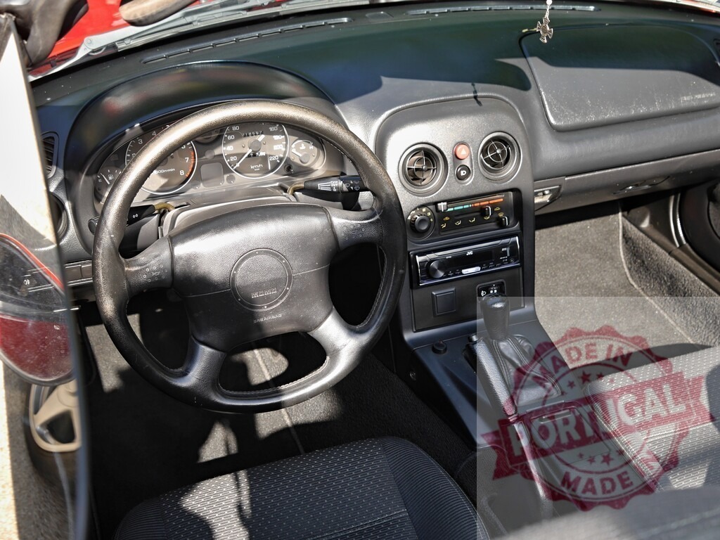 Mazda MX-5 Miata convertible car interior dashboard | Inside a Mazda MX-5 Miata convertible car detailing the dashboard and steering wheel - Realisiert mit Pictrs.com