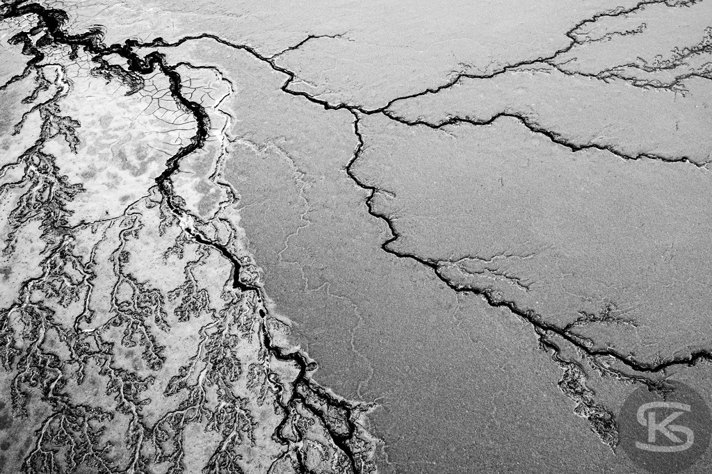 Ground Levels – Abstrakte Landschaften entwässerter Seen aus der Vogelperspektive | Ground Levels zeigt Drohnenaufnahmen entwässerter Seegründe, die zwischen Realität und Abstraktion oszillieren. Rinnsale, Pfützen und Muster verwandeln sich aus der Luft zu abstrakten Kompositionen – Fotokunst von Stefan Kuhn. - Realisiert mit Pictrs.com