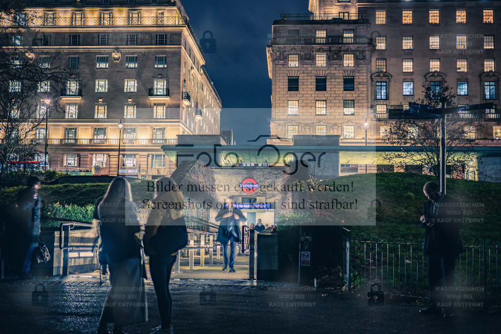 Green Park Station bei Nacht | Ein Blick auf die nächtliche Atmosphäre Londons: Die Lichter der Stadt spiegeln sich in den Fassaden rund um die Green Park Station.Menschen eilen durch das kühle Abendlicht – ein Moment zwischen Alltag und Großstadtflair, eingefangen im Herzen von London. - Realisiert mit Pictrs.com