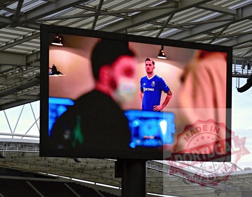 Football player on stadium jumbotron screen displaying live sports | Footballer Toni Martínez wearing a blue jersey appearing on a stadium jumbotron during a match - Realisiert mit Pictrs.com