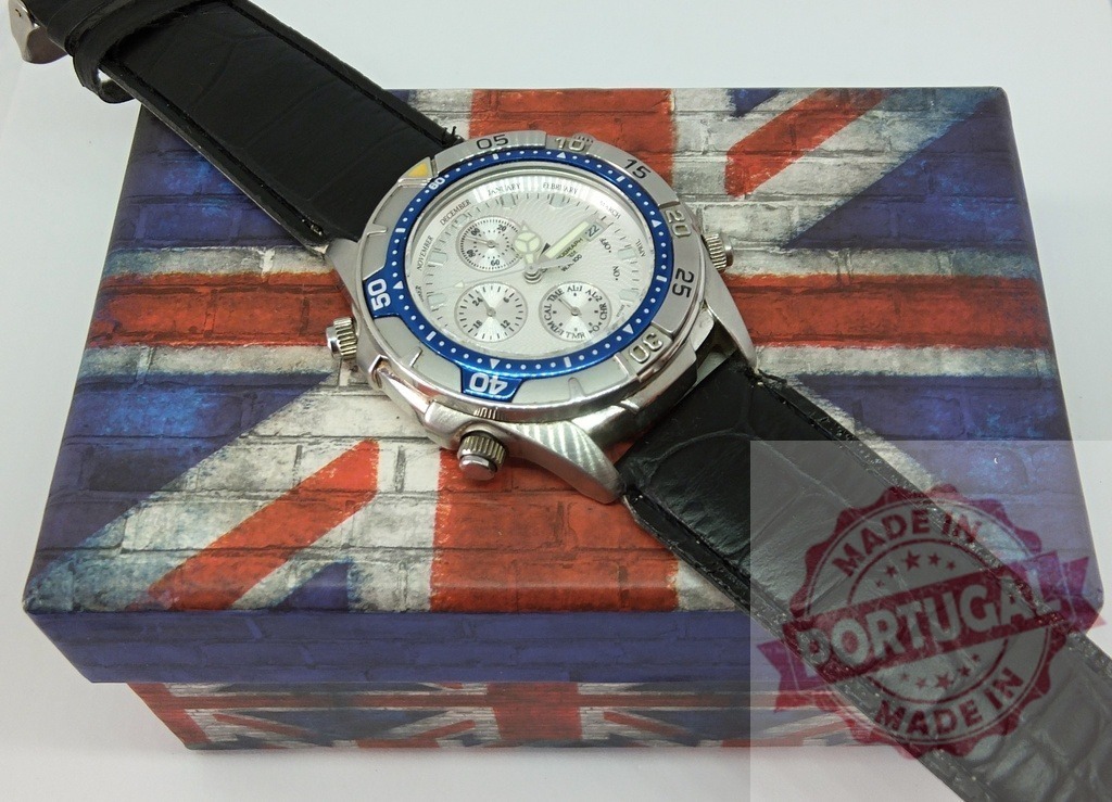 Wristwatch with black strap on Union Jack box | Silver chronograph wristwatch with a black leather strap resting on a decorative box with a Union Jack flag design - Realisiert mit Pictrs.com