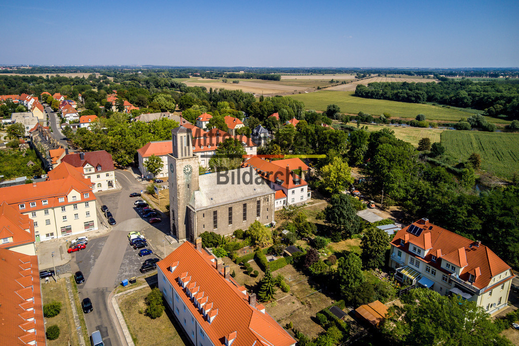 Leuna-0004 | Die Luftaufnahmen zeigen Leuna mit seiner gewachsenen Stadtstruktur und den unterschiedlichen Bereichen des Stadtgebietes. Aus der Vogelperspektive werden Wohngebiete, Straßen, Grünflächen und die Einbettung der Stadt in die umgebende Landschaft sichtbar. Die Bilder dokumentieren Leuna im Saalekreis aus der Vogelperspektive. hier: Friedenskirche - Realisiert mit Pictrs.com