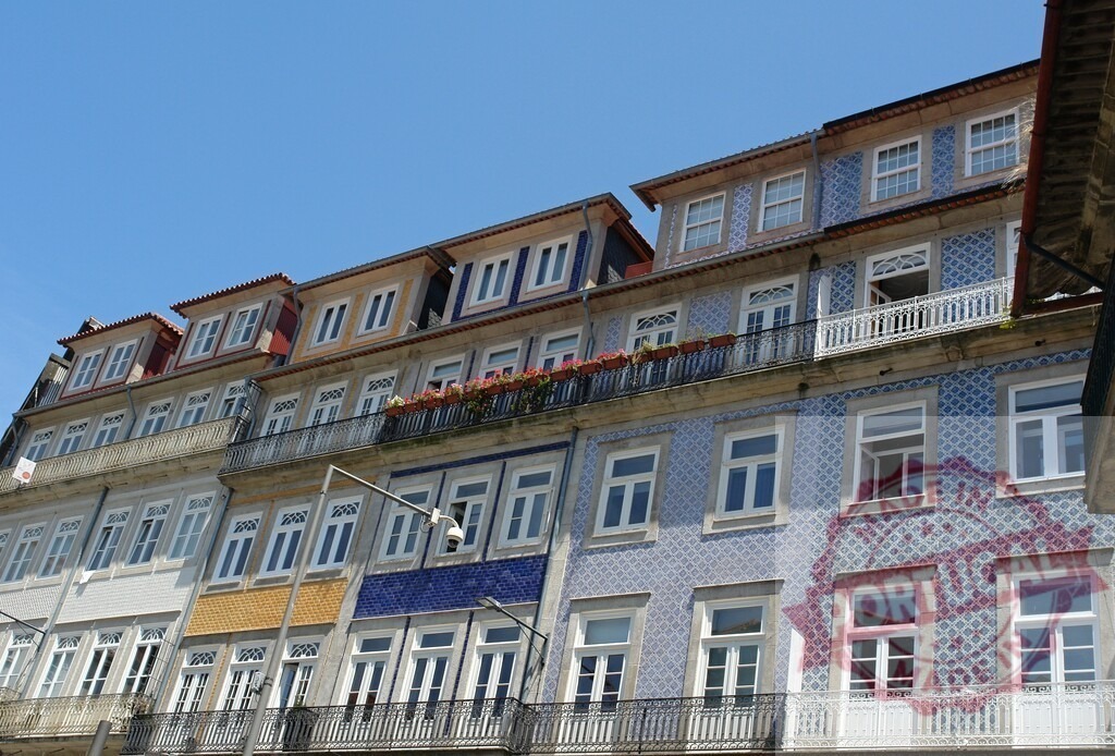 Porto building facades showing traditional Portuguese azulejo tiles | Row of colorful traditional buildings standing under a clear blue sky in Porto, Portugal - Realisiert mit Pictrs.com