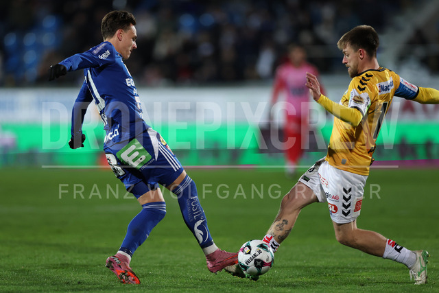TSV Egger Glas Hartberg vs SV Oberbank Ried – Austrian Bundesliga Match | The image shows Lukas Fridrikas (Hartberg) and Philipp Pomer (Ried) attacks the ball, at the Bundesliga match TSV Hartberg vs SV Ried at Profertil Arena Hartberg. 22.11.2025