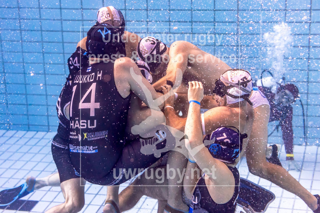 24. - 26.11.2023: Unterwasser-Rugby Champions Cup 2023  | HäSu (Hämeenlinna / Finnland) in blau gegen PF České Budějovice (Budweis / Tschechien) in weiß. Gruppenkampf in der Spielfeldmitte um den Spielball. Der Schiedsrichter im Hintergrund versucht alle Fouls in der Rangelei zu erkennen. - Realisiert mit Pictrs.com