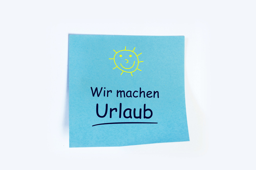 Wir machen  Urlaub - Vorlage auf einem Notizzettel | Notizzettel mit hinzugefügtem Text WIR MACHEN URLAUB vor weißem Hintergrund - Realisiert mit Pictrs.com