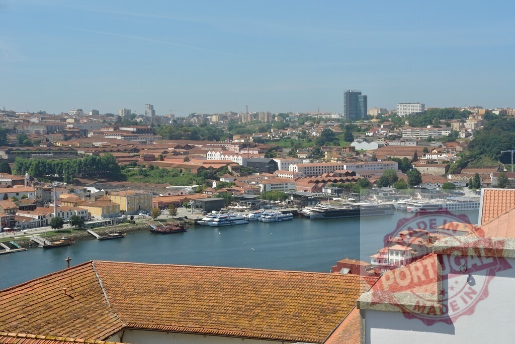 Porto city view with Douro River and Vila Nova de Gaia waterfront. Porto - Portugal | Porto cityscape with boats docked on the Douro River, showing Vila Nova de Gaia - Realisiert mit Pictrs.com