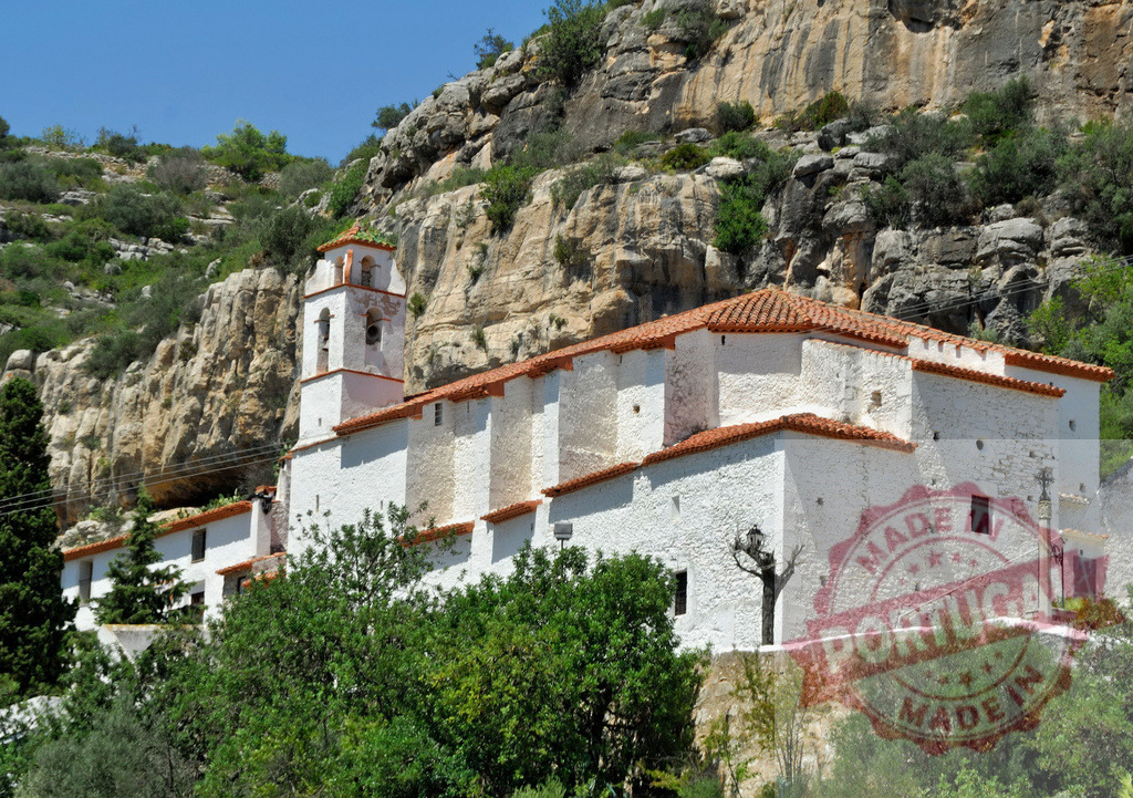 Sant Pere de Figuerola monastery architecture standing at rocky cliff. Spain - Castellon | Historic monastery building with white walls and red tile roofs built into a rocky mountain landscape - Realized with Pictrs.com