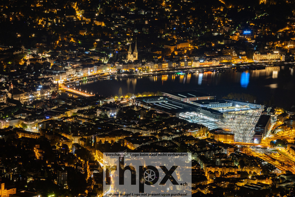 Luzern bei Nacht – Blick auf die Stadt | Der Blick von oben zeigt Luzern bei Nacht. Die Stadtlichter spiegeln sich auf der Reuss und zeigen das charakteristische Stadtbild mit der Kapellbrücke und dem Seeufer. Dieses Motiv eignet sich als Wandbild oder Poster für alle, die Luzern in moderner, klarer Form zeigen möchten.  - Realisiert mit Pictrs.com