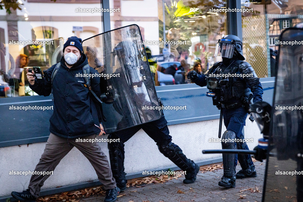 9L6A7412 | Strasbourg, France, 24 octobre 2026. Des manifestants affrontent les forces de l’ordre lors d’une mobilisation dans le centre-ville de Strasbourg. Des policiers interviennent pour disperser des groupes de manifestants, tandis que des gaz lacrymogènes sont utilisés. Des affrontements, des jets de projectiles et des dégradations sont observés dans plusieurs rues. Des barricades et des véhicules en feu témoignent de la tension qui règne en marge de la mobilisation. - Realisiert mit Pictrs.com