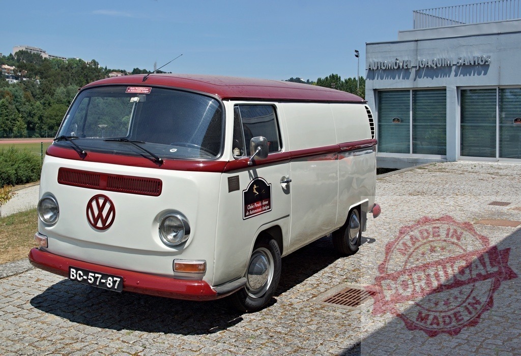 Classic Volkswagen Kombi Van parked near Automóvel Joaquim Santos in Portugal | Shiny vintage Volkswagen Kombi van parked near Automóvel Joaquim Santos dealership in Portugal, showcasing its timeless design - Realized with Pictrs.com