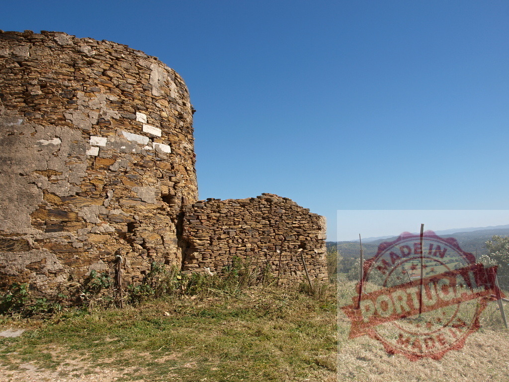 Ancient stone tower ruin standing in a rural landscape | Ancient stone tower ruin showcasing history and old architecture with a clear blue sky - Realized with Pictrs.com