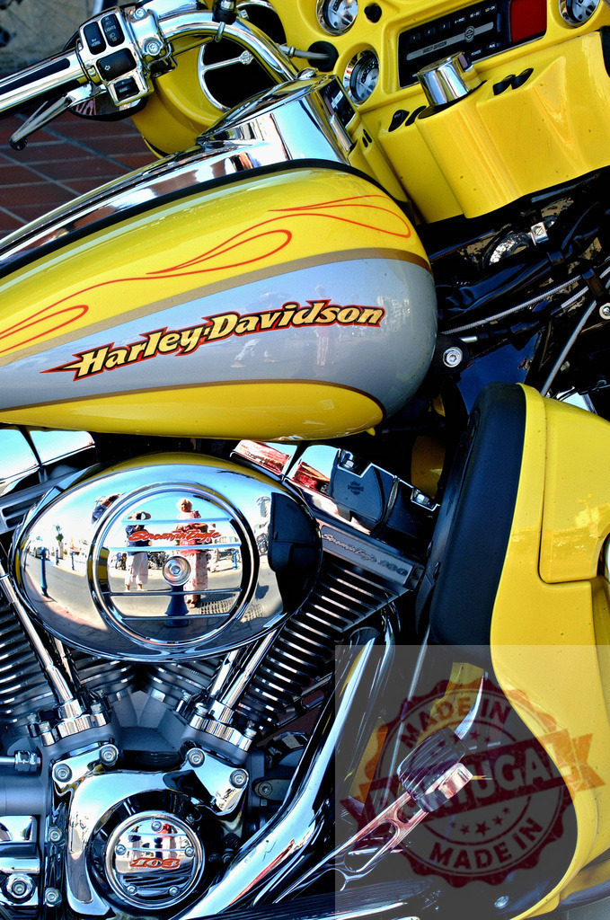 Harley-Davidson yellow gas tank reflecting street scene | Custom yellow Harley-Davidson cruiser with chrome engine details - Realized with Pictrs.com