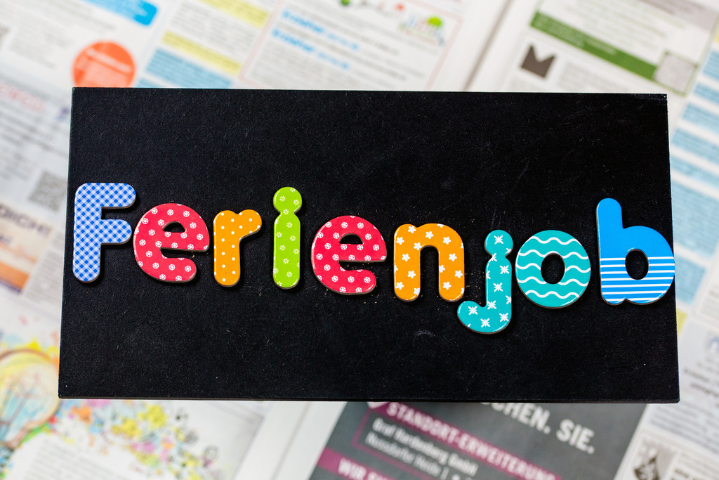 Symbolbild Ferienjob: Tafel mit der Aufschrift FERIENJOB vor den Stellenanzeigen einer Zeitung | Symbolbild Ferienjob: Tafel mit der Aufschrift FERIENJOB vor den Stellenanzeigen einer Zeitung - Realisiert mit Pictrs.com