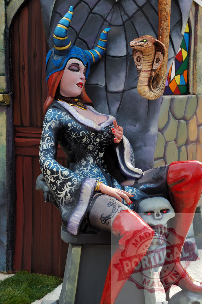 Fantasy character Maleficent witch falla sculpture at Las Fallas. Fallas Fiestas Communidad Valenciana | Falla sculpture depicting a horned witch with red boots and a cobra in Las Fallas - Realized with Pictrs.com