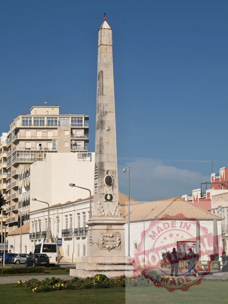 Faro municipal obelisk standing in a city square | Faro municipal obelisk monument commemorating the Peninsular War in a city square under blue sky - Realized with Pictrs.com
