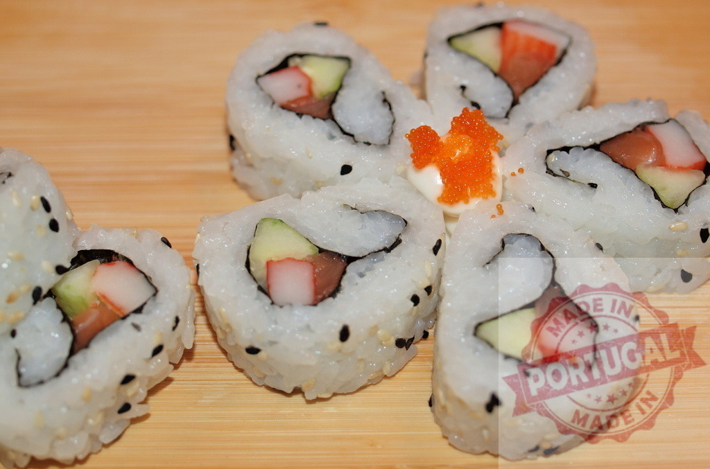 Sushi maki rolls creating flower shape on wood | Sushi maki rolls with cucumber, crab stick, tuna, and masago on a wooden board - Realized with Pictrs.com