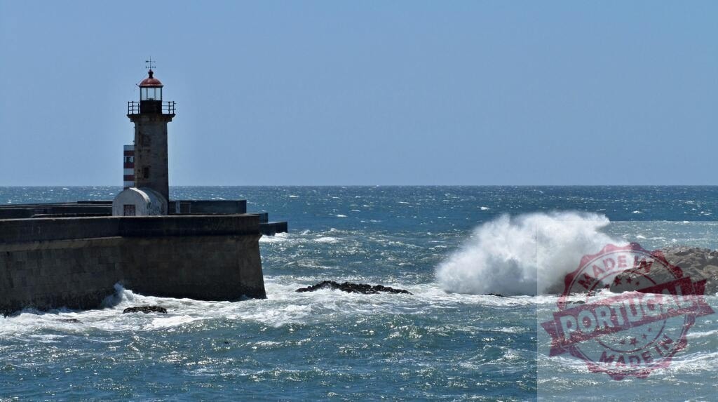 Felgueiras lighthouse standing firm against crushing ocean waves. Portugal - Norte | Felgueiras lighthouse with powerful ocean waves crashing against rocks and seawall structure - Realisiert mit Pictrs.com