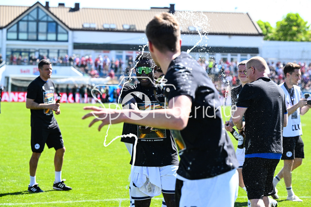SpVgg Unterhaching - Arminia Bielefeld | die Mannschaft aus Bielefeld feiert zusammen mit den Fans dein Sieg und den Aufstieg in Unterhaching / Bierdursche / Bier / Freude / Happy / Gluecklich / 3. Liga: SpVgg Unterhaching - Arminia Bielefeld, Uhlsport Park am 11.05.2025 / Merveille BIANKADI (Arminia Bielefeld 17)