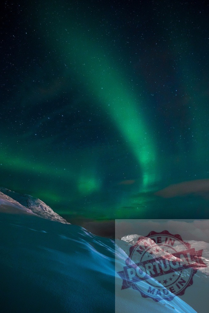 Aurora borealis covering winter mountains with green light | Aurora borealis lights up a star-filled night sky over snow-covered mountains, creating a natural spectacle - Realized with Pictrs.com