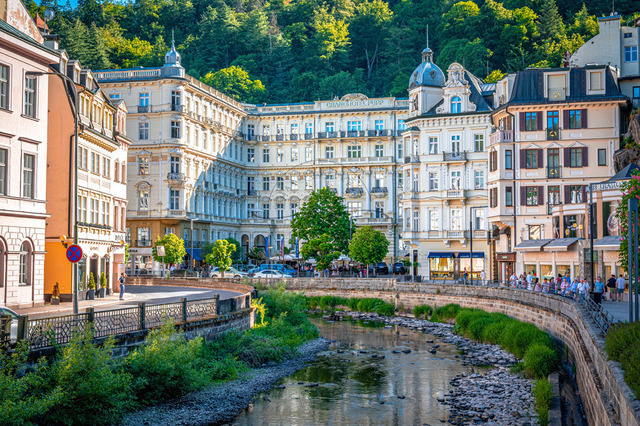 Das Grandhotel Pupp steht in Karlsbad. Menschen gehen entlang des Flusses. Die Gebäude sind gut besucht. Bäume und Sträucher sind sichtbar. Es ist ein klarer Tag | Das Grandhotel Pupp steht in Karlsbad. Menschen gehen entlang des Flusses. Die Gebäude sind gut besucht. Bäume und Sträucher sind sichtbar. Es ist ein klarer Tag. - Realisiert mit Pictrs.com
