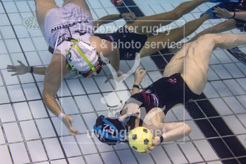 24. - 26.11.2023: Unterwasser-Rugby Champions Cup 2023  | Damen-Spiel: UWRC Wien (Österreich) in blau gegen Helvetia (Schweiz) in weiß. Die Wienerin Theresa Wihann (blau #52) versucht ihre Mitspielerin, an der Schweizerin Kathrin Heierli (weiß #42) vorbei, anzupassen. - Realisiert mit Pictrs.com