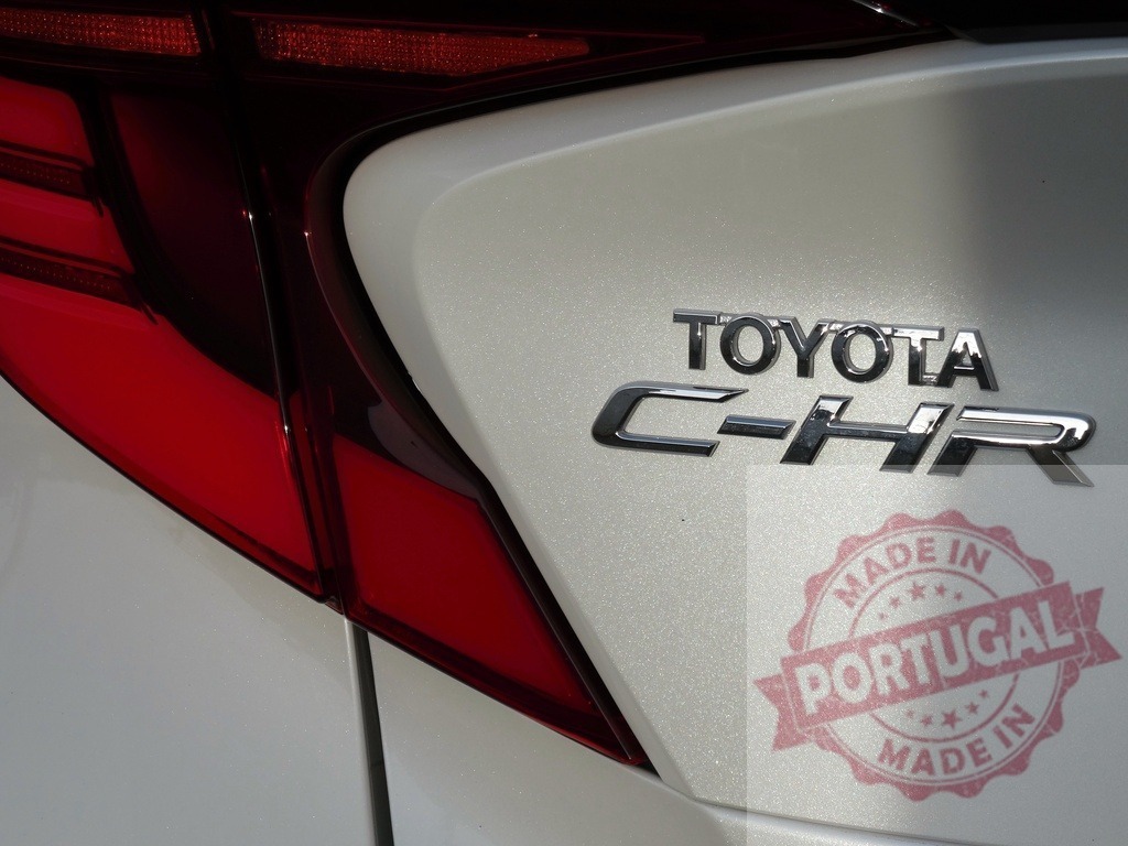 Toyota C-HR emblem on a modern car trunk | Toyota C-HR model name and logo on a car trunk with a red tail light - Realized with Pictrs.com