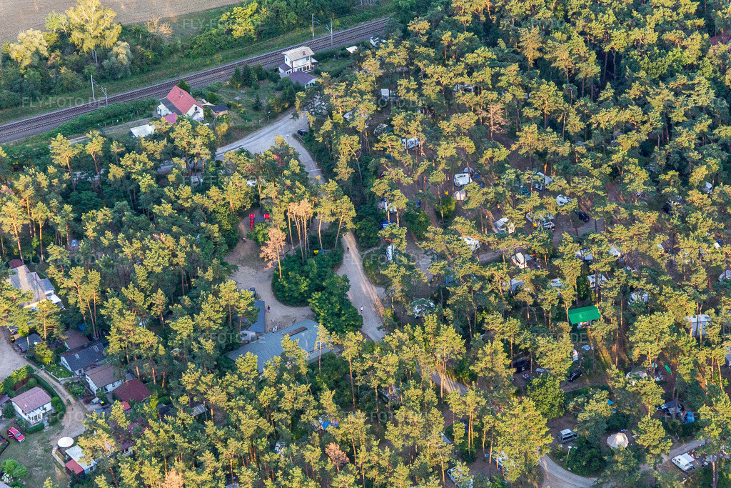 Wohnwagen und Zelte unter Kiefern auf dem Campingplatz - und Zeltplatz Camping am Oberuckersee | Luftbild: Wohnwagen und Zelte unter Kiefern auf dem Campingplatz - und Zeltplatz Camping am Oberuckersee im Ortsteil Warnitz in Oberuckersee im Bundesland Brandenburg in Deutschland. Foto: IMG_116277.jpg vom 17.07.2019 durch Werner Riehm/FLY-FOTO.de - Realisiert mit Pictrs.com
