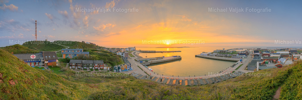 Panorama bei Sonnenaufgang | Blick auf das Ober-, Mittel- und Unterland sowie den Hafen der Hochseeinsel Helgoland bei einem herrlichen Sonnenaufgang im Mai. Im Hintergrund ist die Nachbarinsel "Düne" zu sehen, die heutzutage nur noch per Boot erreichbar ist. Das Panoramabild besteht aus 18 Aufnahmen und hat eine sehr hohe Auflösung von 25536 x 8512 Pixeln. Es ist somit ideal für sehr große Drucke geeignet. - Realisiert mit Pictrs.com