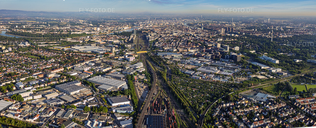 Luftbild: Stadtteilansicht aus Osten beidseits der Bahngleise bis zum Rhein mit Rhenus Automotive und John Deere GmbH & Co KG vorn Gewerbegebiet Fahrlach im Ortsteil Almenhof in Mannheim im Bundesland Baden-Württemberg in Deutschland. – Foto: IMG_157427-Pano.jpg vom 18.06.2026 durch Werner Riehm/FLY-FOTO.de – Auflösung des Originals: 10210 x 4138 px – Automotive – John Deere DE
