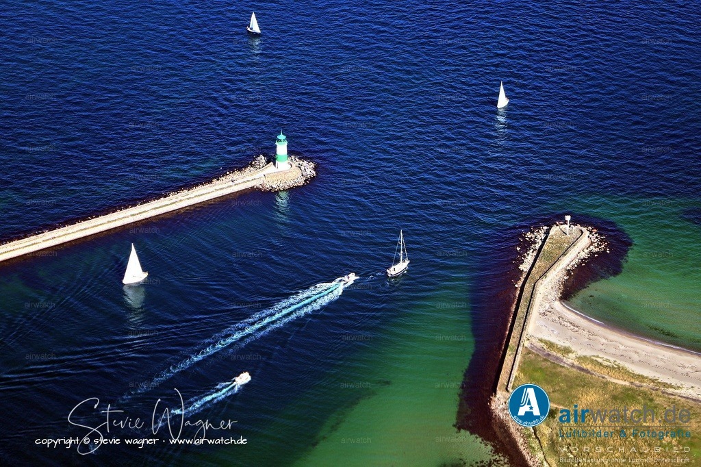 Luftbild Schleimünde - Die Einfahrt in die Schlei erfolgt bei Schleimünde. | Die Einfahrt in die Schlei erfolgt bei Schleimünde, wo die Schlei in die Ostsee übergeht. Die Einfahrt liegt zwischen Kiel und Flensburg, etwa mittig zwischen der Marina Damp und dem Leuchtturm Falshöft. Die Schlei ist durchgängig von Schleimünde bis Schleswig betonnt, wobei die roten Tonnen in Fahrtrichtung Südwest/West an Backbord und die grünen an Steuerbord stehen; es gilt das Rechtsfahrgebot und Kurven sollten nicht geschnitten werden. Das Fahrwasser beginnt auf der Ostsee bei der rot-weißen Ansteuerungstonne Schlei (Kennung: Oc. 4 Sekunden) und führt an dem 14,3 Meter hohen, grün-weiß-geringelten Leuchtturm Schleimünde vorbei, der auf der Nordmole der Schleimündung thront (Tragweite: 13 Seemeilen, Kennung: LFl. (3) WGR, 20 Sekunden).
