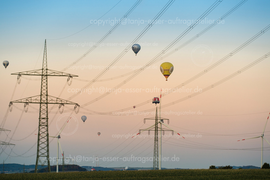 140 Ballons in den Stromleitungen | Warsteiner Internationale Montgolfiade ist die Veranstaltung mit Heißluftballons. Die Ballons fliegen in der Nähe von Stromleitungen.