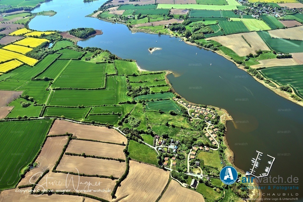 Luftbild Ostseefjord Schlei, Bohnert, Marina Huelsen, Sportboothafen | Marina Hülsen: Neben den Liegeplätzen verfügt die Marina über Ferienhäuser, die vom Betreiber vermietet werden. Die Ferienhäuser liegen in unmittelbarer Nähe zur Marina und bieten direkten Zugang zum Wasser. Die Anfahrt erfolgt über die Gemeinde Kosel, wobei Hinweisschilder die Route von Bohnert zur Marina Hülsen markieren.