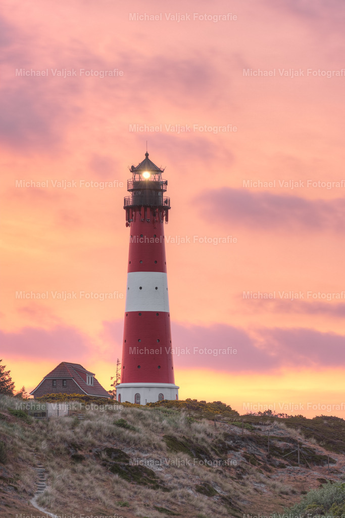 Leuchtturm in Hörnum | Blick zum Leuchtturm in Hörnum auf Sylt kurz vor Sonnenaufgang. Der Himmel wird in ein kräftiges rot, orange, lila und gelb getaucht, ein einzigartiges und schönes Schauspiel. - Realisiert mit Pictrs.com